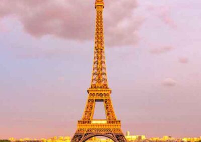 Eiffel Tower glowing at sunset with a dramatic sky