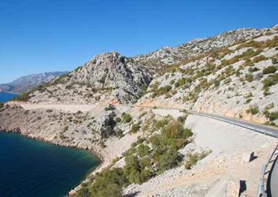 Scenic coastal road along the Adriatic Sea in Croatia with rugged cliffs and blue waters.