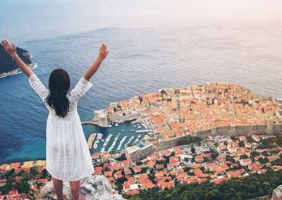 Tourist overlooking Dubrovnik’s Old Town from a scenic hilltop viewpoint.